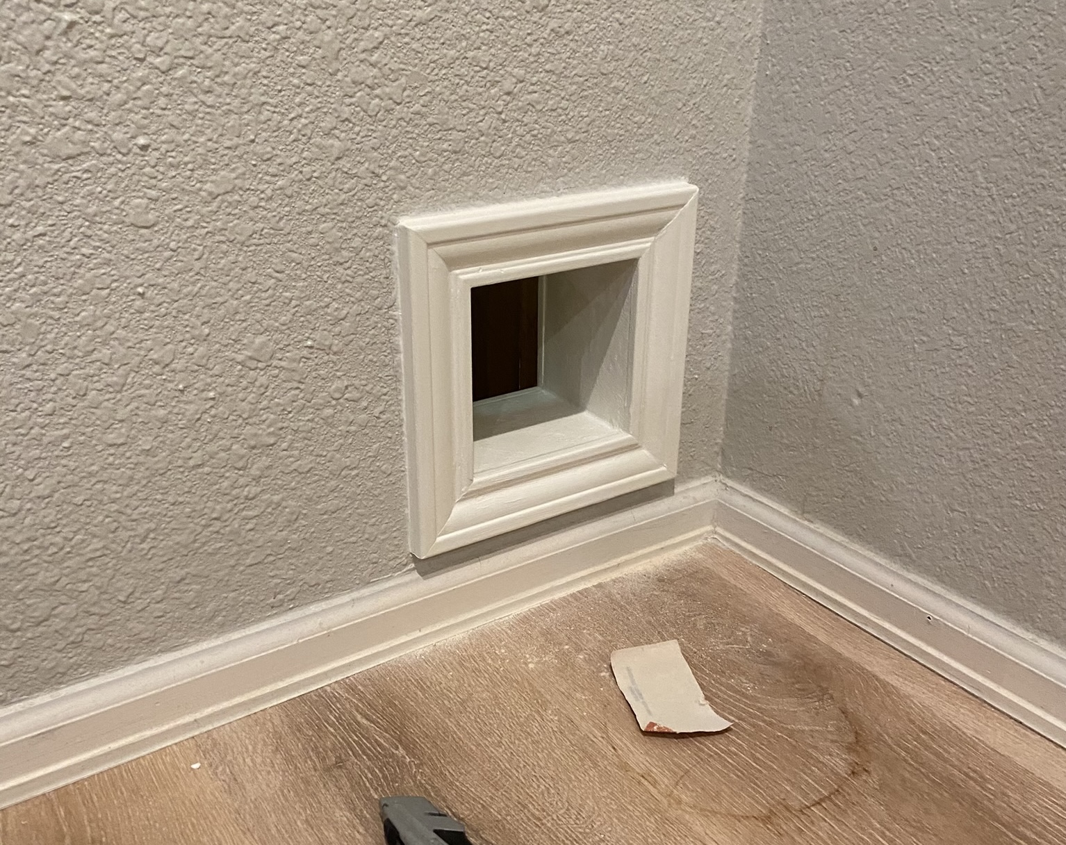 Small trimmed opening in wall to allow cat to enter closet